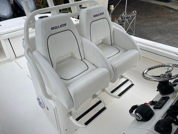 Slide: The Image of 2016 Regulator 34SS boat cockpit with dual white captain's chairs and steering controls. - 29