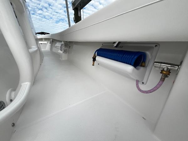 Slide: The Image of 2024 Regulator 41 boat deck with hose storage and clean white finish. - 31