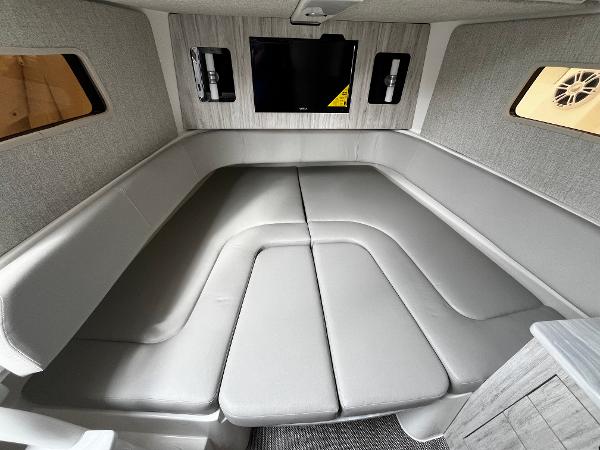 Slide: The Image of 2024 Regulator 41 boat interior cabin with grey seating and mounted TV. - 37