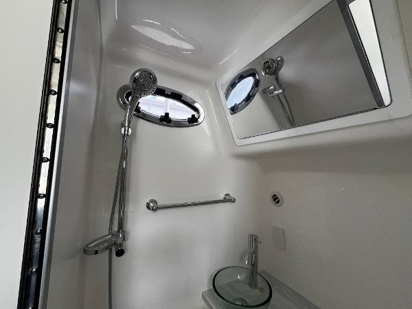 Slide: The Image of 2024 Regulator 41 boat bathroom with shower, mirror, and sink. - 42