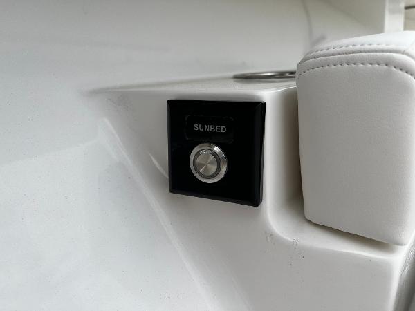 Slide: The Image of Regulator 41 2024 boat sunbed control button and white cushioned seat. - 47