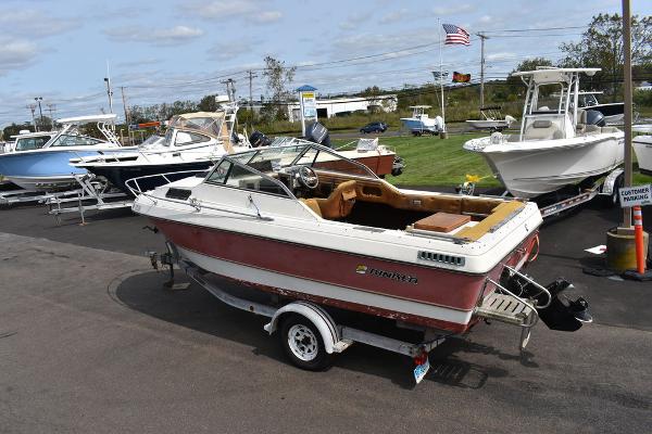 Slide: The Image of 1983 Rinker 204 Cuddy Cabin boat on trailer, parked in a marina lot. - 1
