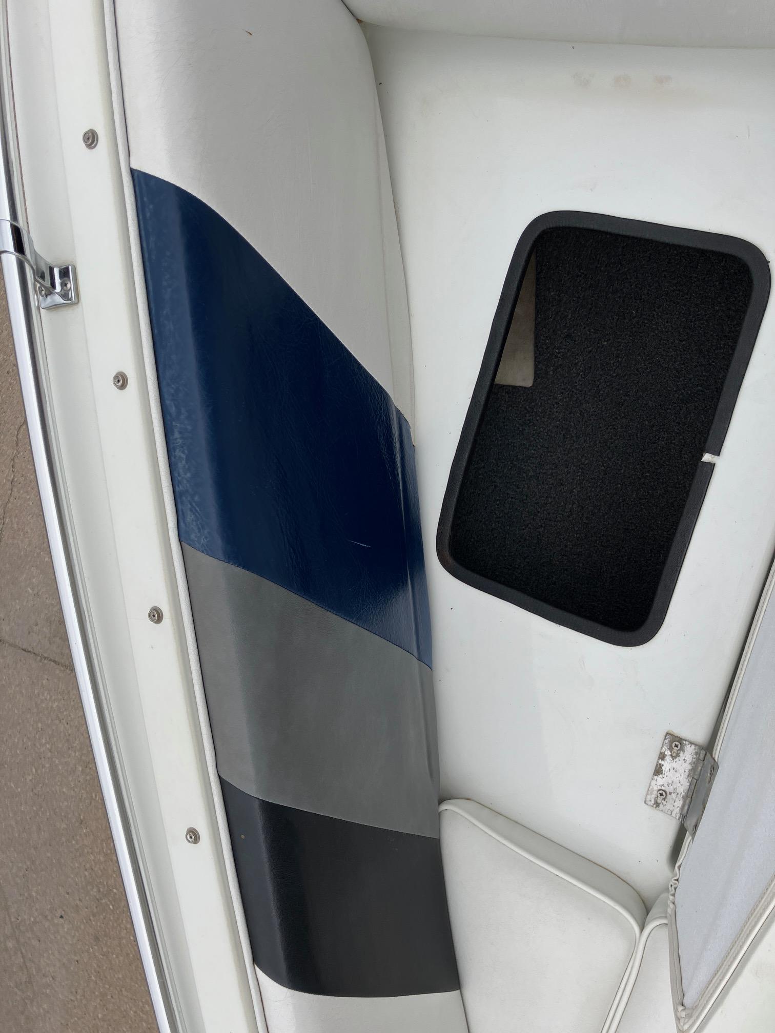 Slide: The Image of 1989 Rinker 206 Open Bow boat interior with blue and gray seating. - 17