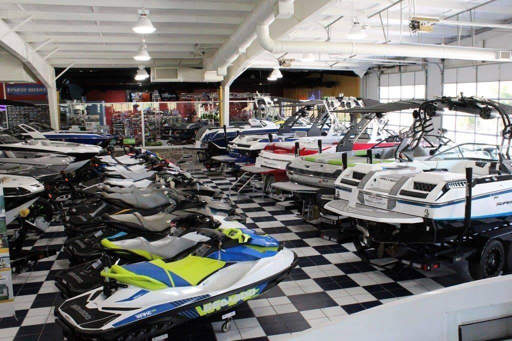 Slide: The Image of Indoor showroom displaying various jet skis and boats, including a 1994 Rinker 209 Captiva. - 24