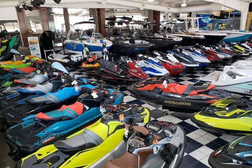 Slide: The Image of Showroom with various jet skis and a 1994 Rinker 209 Captiva boat on display. - 25