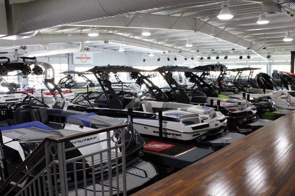 Slide: The Image of Indoor showroom displaying various boats, including a 1994 Rinker 209 Captiva model. - 26