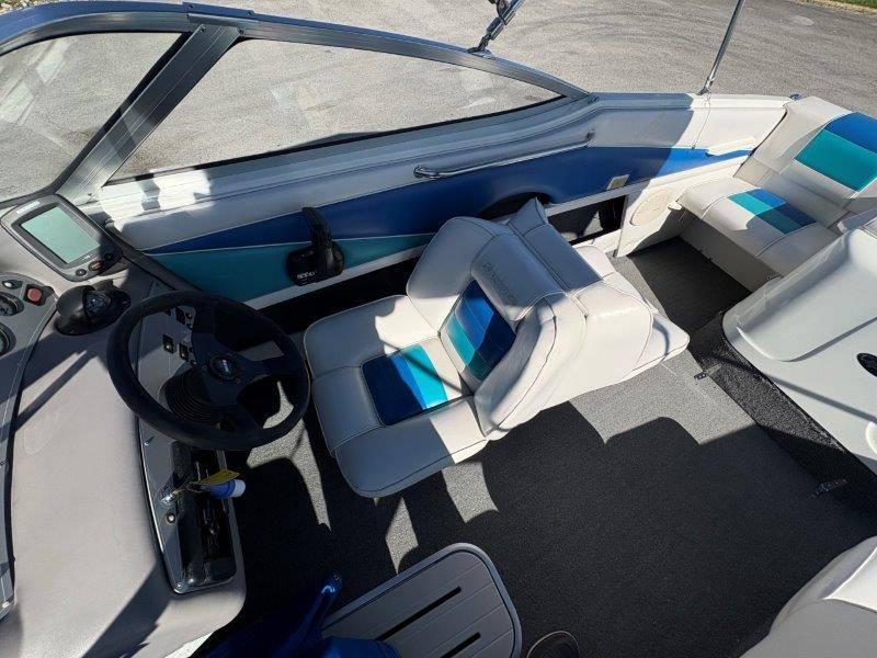 Slide: The Image of 1994 Rinker 209 Captiva boat interior with blue and white seating, steering wheel, and dashboard. - 29