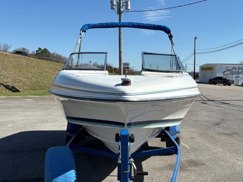 Slide: The Image of 1994 Rinker 209 Captiva boat on trailer, front view, blue canopy, outdoor setting. - 3