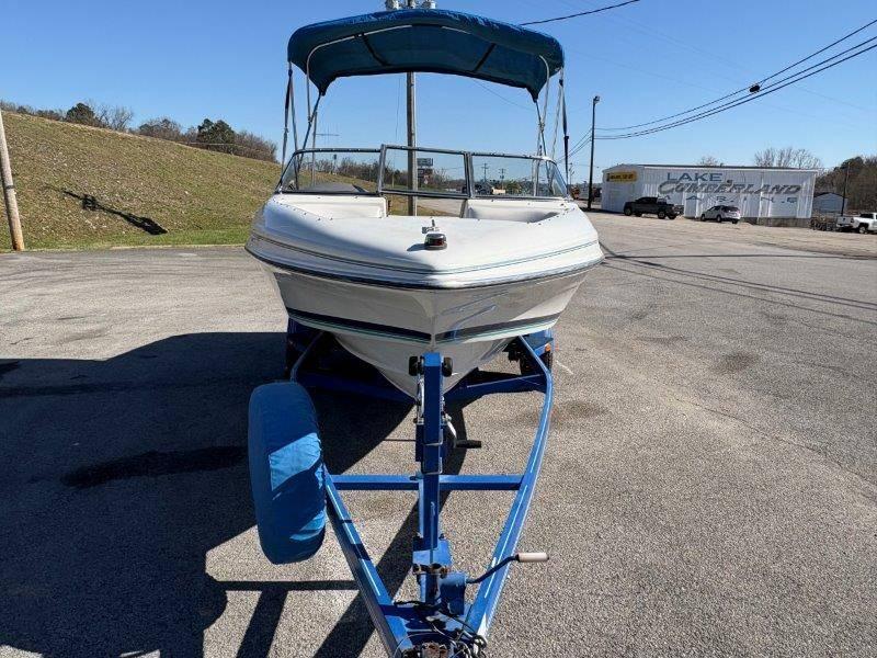 Slide: The Image of 1994 Rinker 209 Captiva boat on trailer with blue canopy, parked outdoors. - 38