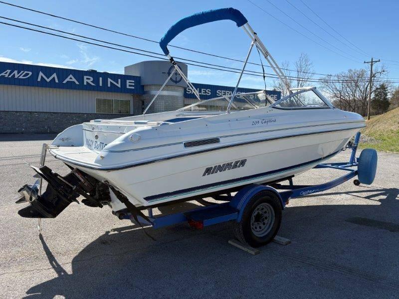 Slide: The Image of 1994 Rinker 209 Captiva boat on trailer, parked outside a marine sales building. - 4