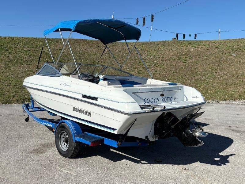 Slide: The Image of 1994 Rinker 209 Captiva boat on trailer with blue canopy, named "Soggy Bottom." - 45