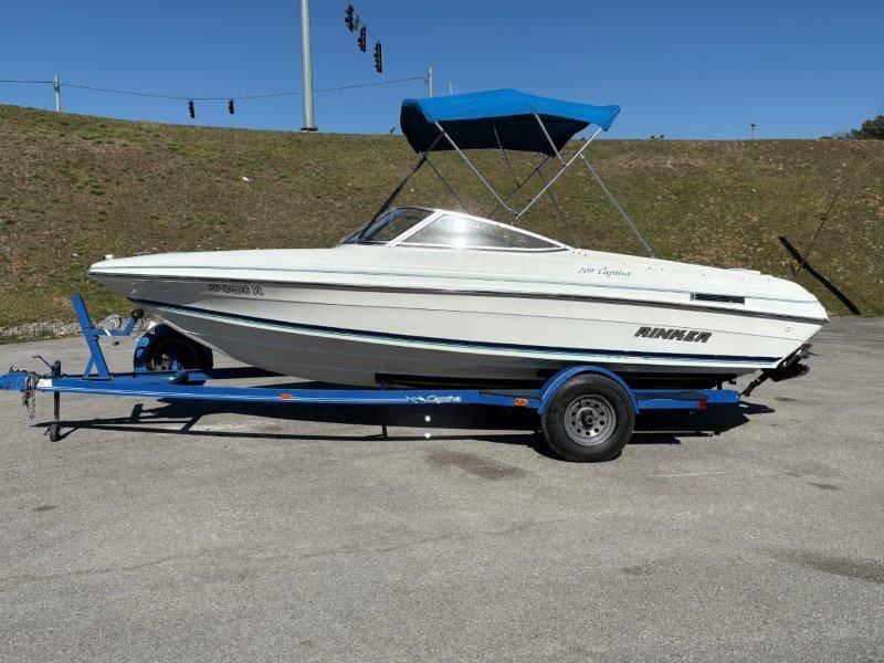 Slide: The Image of 1994 Rinker 209 Captiva boat on trailer with blue canopy, parked outdoors. - 49