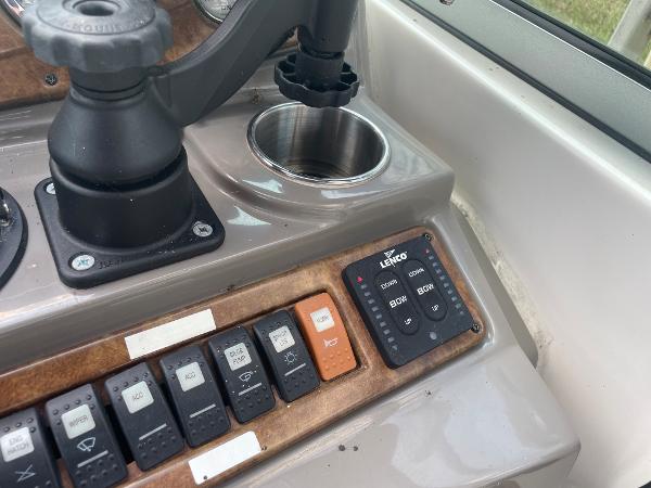 Slide: The Image of Control panel of a 2008 Rinker 260 Express Cruiser boat with switches and cup holder. - 18