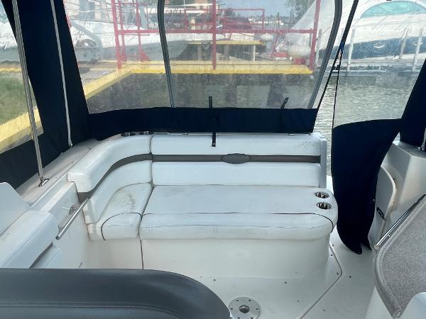 Slide: The Image of 2008 Rinker 260 Express Cruiser interior with white seating and cup holders. - 7
