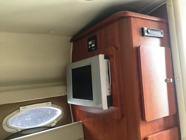 Slide: The Image of Interior cabin of 2007 Rinker 270 Express Cruiser with TV and wooden cabinetry. - 13
