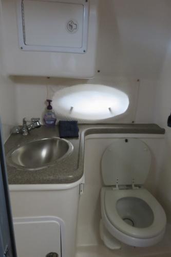 Slide: The Image of 2008 Rinker 280 Express Cruiser bathroom with sink, toilet, and oval window. - 17