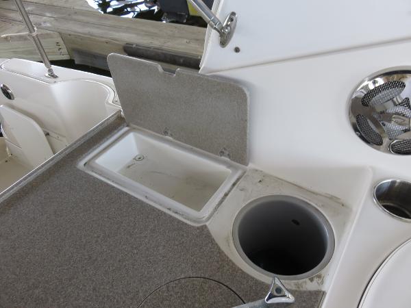 Slide: The Image of 2008 Rinker 280 Express Cruiser deck with storage compartment and cup holder. - 21
