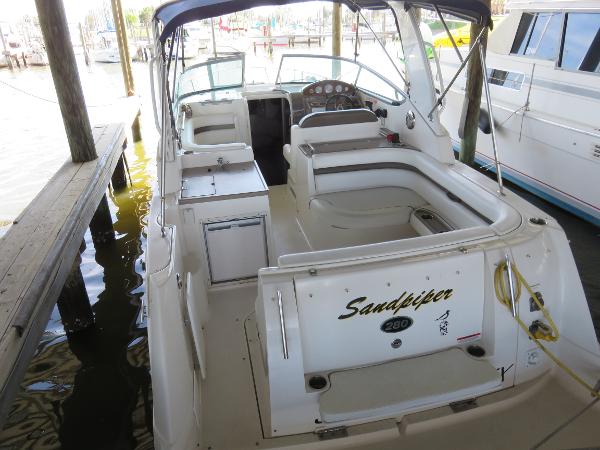 Slide: The Image of 2008 Rinker 280 Express Cruiser docked, featuring spacious seating and helm area. - 3