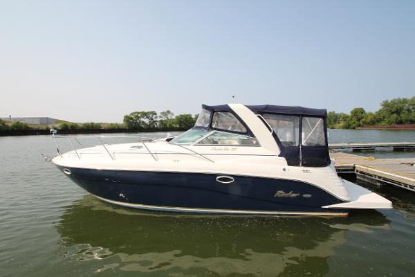 Slide: The Image of 2005 Rinker 312 Fiesta Vee boat docked on calm water. - 1