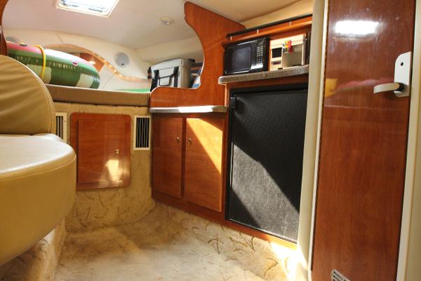 Slide: The Image of Interior of 2005 Rinker 312 Fiesta Vee boat with kitchenette and seating area. - 30