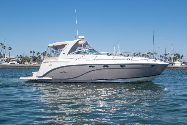 Slide: The Image of 2008 Rinker 400 Express Cruiser on calm water with marina background. - 1