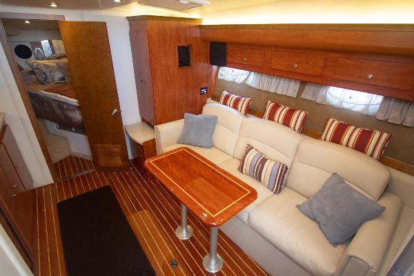 Slide: The Image of Interior of 2008 Rinker 400 Express Cruiser with sofa, table, and striped cushions. - 10