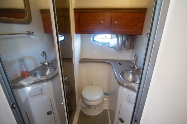 Slide: The Image of 2008 Rinker 400 Express Cruiser bathroom with dual sinks and wooden cabinets. - 17