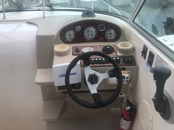 Slide: The Image of 2003 Rinker Fiesta Vee 270 boat dashboard with steering wheel and control panel. - 3