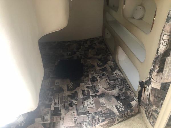Slide: The Image of 2003 Rinker Fiesta Vee 270 cabin interior with patterned bedding. - 8