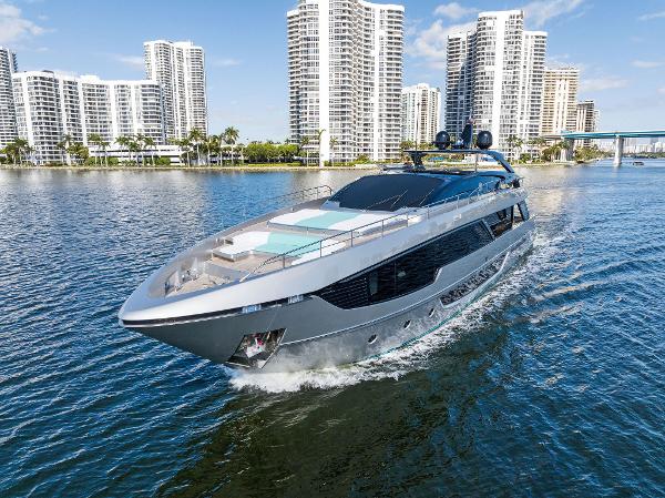 Slide: The Image of 2024 Riva 102 Corsaro Super yacht cruising near modern city skyline. - 0