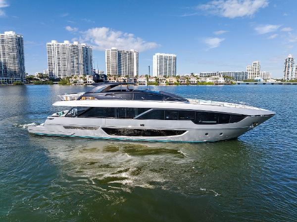 Slide: The Image of Luxurious 2024 Riva 102 Corsaro Super yacht cruising near modern city skyline. - 1