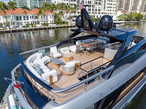 Slide: The Image of Luxurious 2024 Riva 102 Corsaro Super yacht with elegant outdoor seating on a scenic waterway. - 12