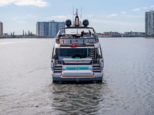Slide: The Image of 2024 Riva 102 Corsaro Super yacht on calm water, city skyline in background. - 26