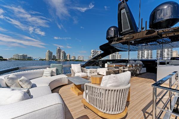 Slide: The Image of Luxurious 2024 Riva 102 Corsaro Super yacht deck with modern seating and city skyline. - 44