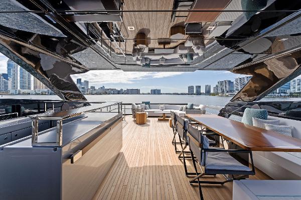 Slide: The Image of Luxurious 2024 Riva 102 Corsaro Super yacht deck with modern seating and city skyline view. - 46