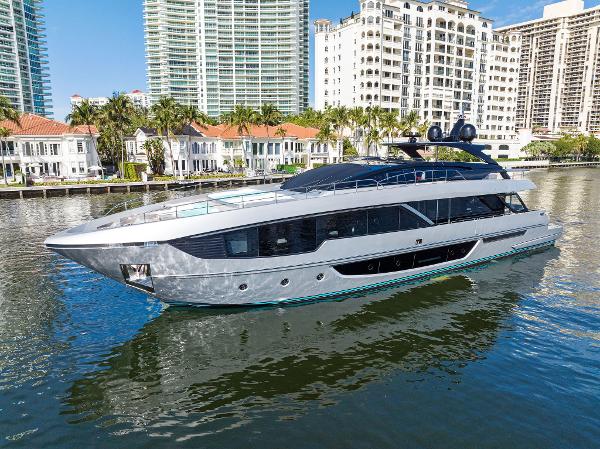 Slide: The Image of 2024 Riva 102 Corsaro Super yacht on a sunny waterfront with luxury buildings. - 5