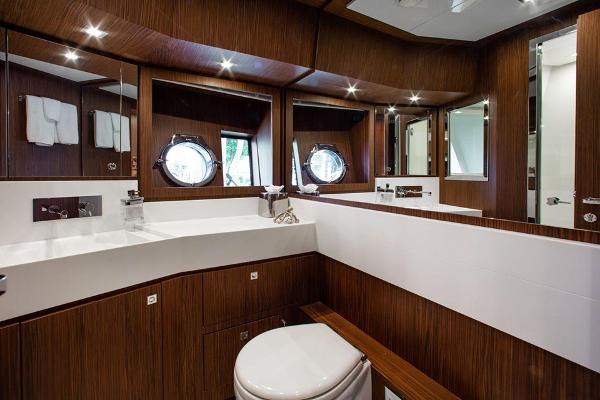 Slide: The Image of Luxurious bathroom on the 2017 Riva 88 Domino Super yacht with wood paneling and porthole windows. - 39