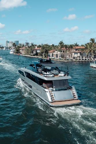 Slide: The Image of Luxurious 2019 Riva ARGO yacht cruising through scenic waterfront with palm trees and blue sky. - 27