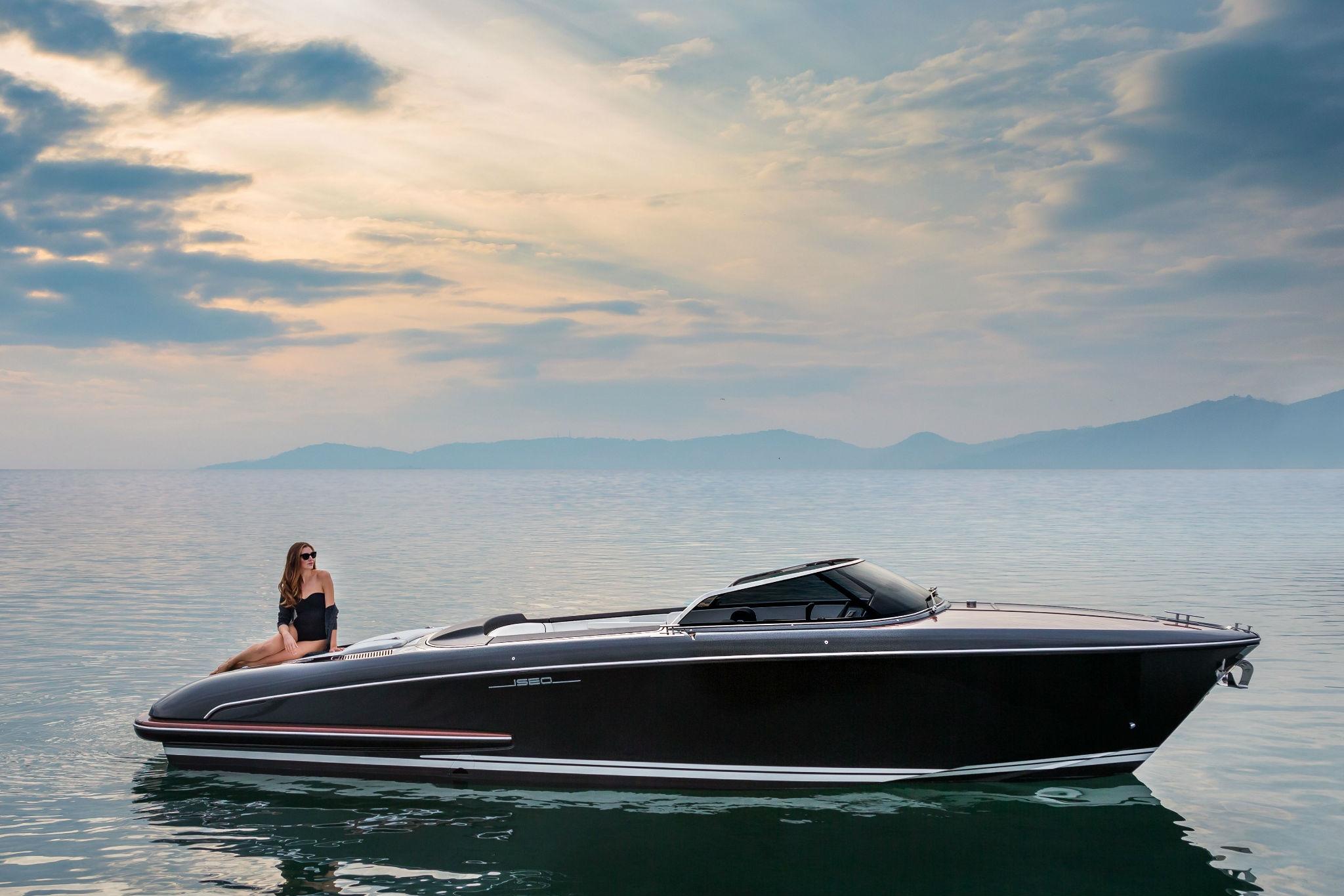Slide: The Image of 2025 Riva Iseo luxury boat on calm water with scenic mountain backdrop. - 1
