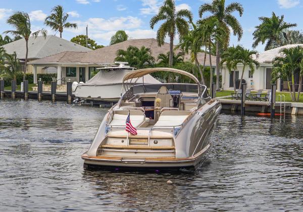 Slide: The Image of Riva Rama 2010 luxury boat docked near waterfront homes with palm trees. - 2