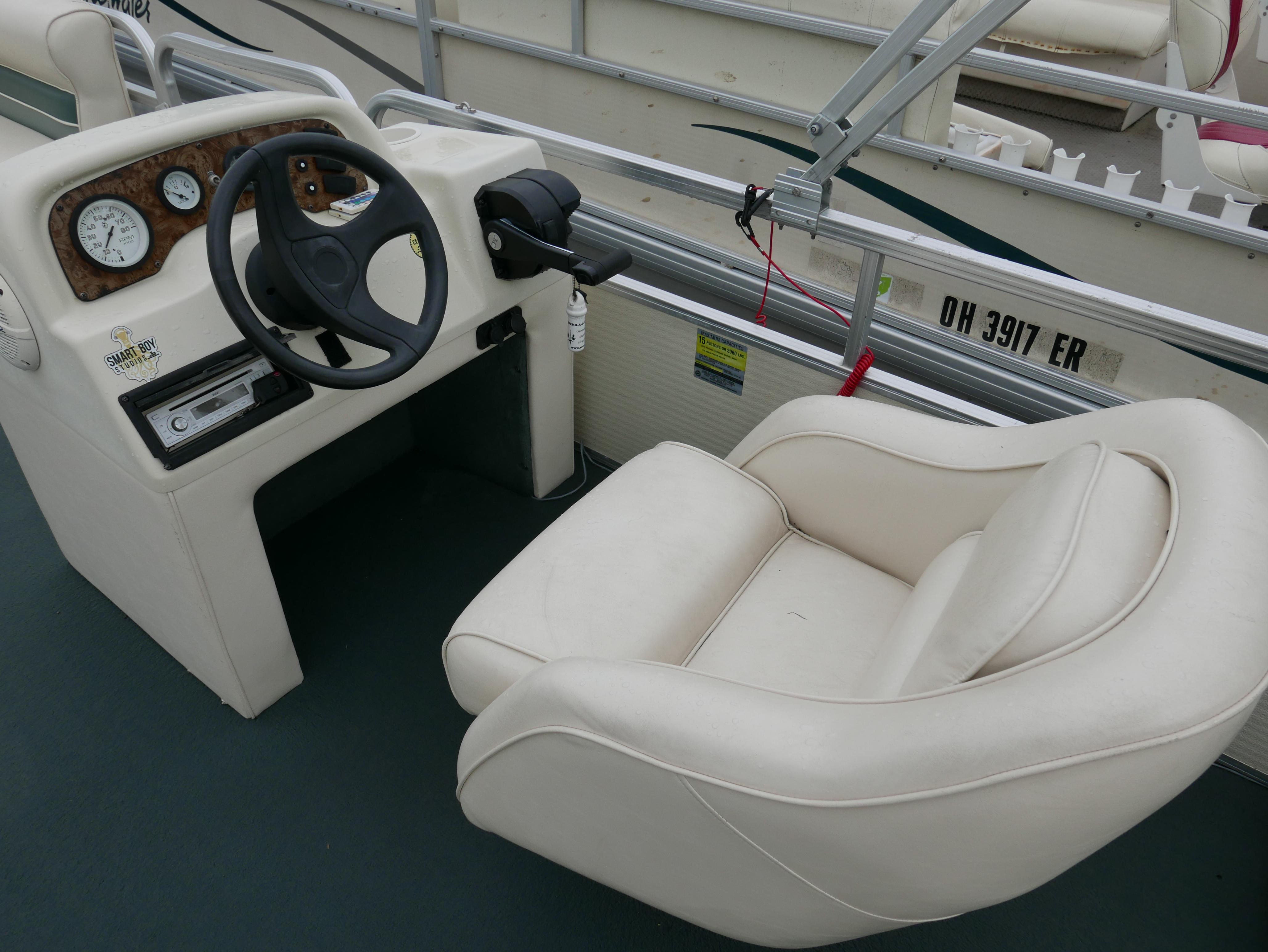 Slide: The Image of Steering console of a 2000 Riviera Cruiser Cruise boat with white seating. - 7