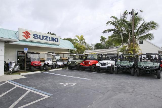 Slide: The Image of Suzuki dealership with various off-road vehicles parked outside. - 40