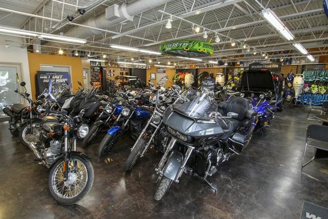 Slide: The Image of Showroom filled with various motorcycles and gear, featuring a 2024 Robalo 206 Cayman. - 41