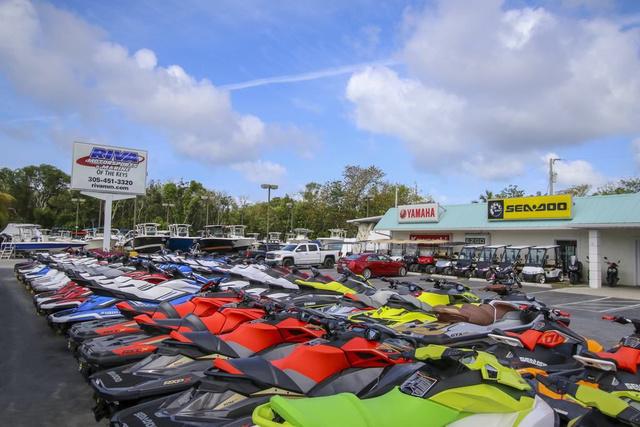 Slide: The Image of 2024 Robalo 206 Cayman boats and jet skis at dealership, Yamaha and Sea-Doo signage visible. - 47