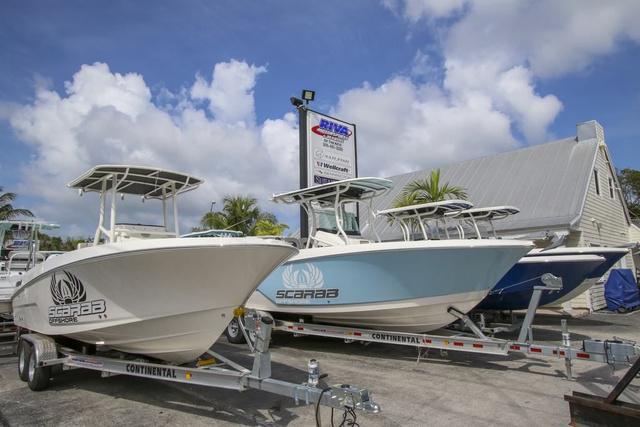 Slide: The Image of 2024 Robalo 206 Cayman boats on trailers at dealership under blue sky. - 48