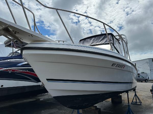 Slide: The Image of 1994 Robalo 2160 Cuddy Cabin boat on stands, side view, cloudy sky background. - 1