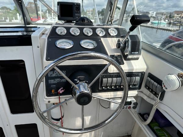 Slide: The Image of 1994 Robalo 2160 Cuddy Cabin boat helm with steering wheel, gauges, and controls. - 7
