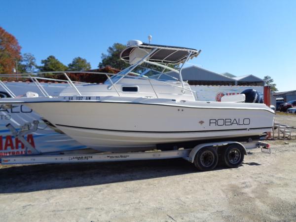 Slide: The Image of 2000 Robalo 2240 Walkaround boat on a trailer in a yard. - 15