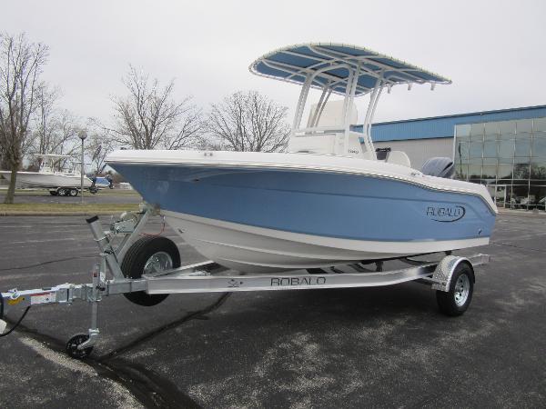 Slide: The Image of 2024 Robalo R180 Center Console boat on a trailer in a parking lot. - 0