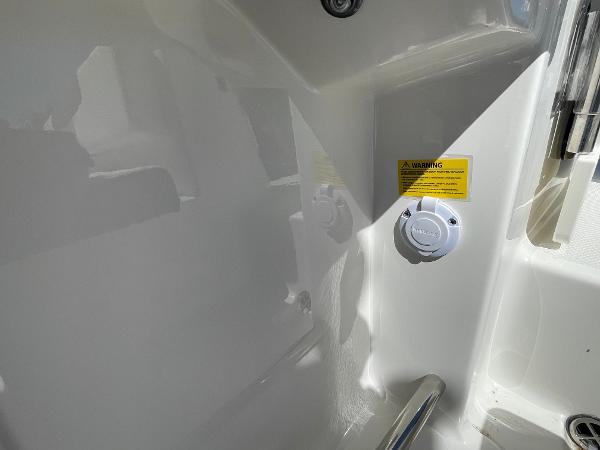 Slide: The Image of 2024 Robalo R222 Explorer interior detail with warning label and fixture. - 13